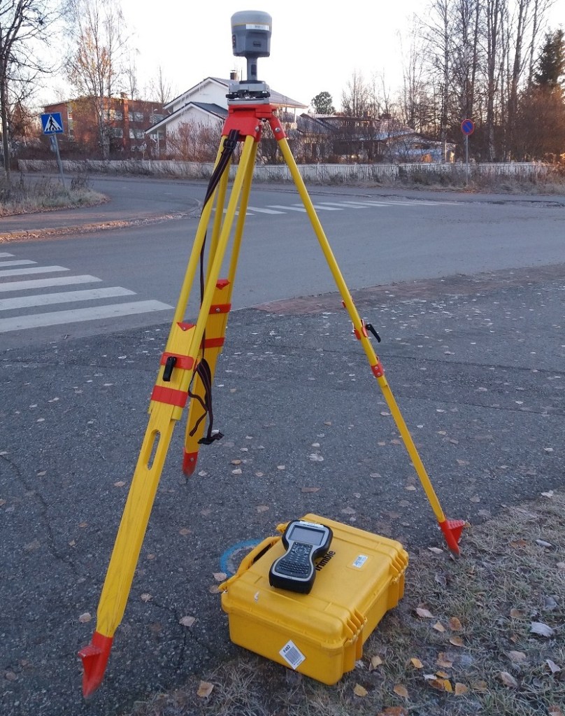 Geodeettinen satelliittipaikannin asennettuna kolmijalalle staattista mittausta varten.
